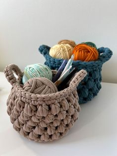 a basket with yarn and crochet hooks in it sitting on a white surface