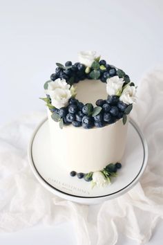 a white cake topped with blueberries and flowers