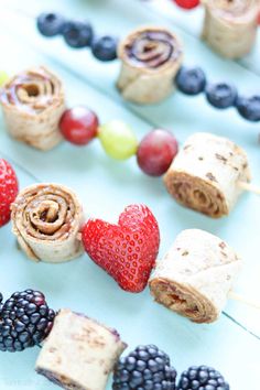 an assortment of fruits and snacks on sticks