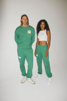 Designed to inspire your inner bravery, our OG graphic sweatpants have two side pockets, an interior adjustable drawstring, and a relaxed fit. GRAPHICS Front: 'Brave the Label' logo puff paint graphic Back: 'Smiley Face' graphic Back: 'We Are' puff paint graphic - "We are Resilient, Fearless, Daring, Day Dreamers, Reform Seekers, Human Beings. Brave the Label". COLORWAYSAvailable in Jet Black + Lucky Green MATERIALSOur sweatpants are made from 100% premium cotton. Made in Los Angeles from a soft Green Cotton Tracksuit With Pockets, Green Sportswear Tracksuit For Leisure, Green Athleisure Tracksuit For Streetwear, Green Leisure Tracksuit, Green Leisure Tracksuit In Sportswear Style, Green Joggers With Side Pockets For Streetwear, Green Joggers With Elastic Waistband For Streetwear, Casual Graphic Print Sweatpants For Sports, Green Sporty Tracksuit With Pockets