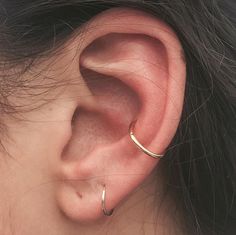 a close up of a person's ear with a gold hoop