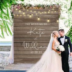 a bride and groom standing in front of a wooden sign