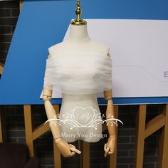 a mannequin wearing a white dress on display in front of a blue wall