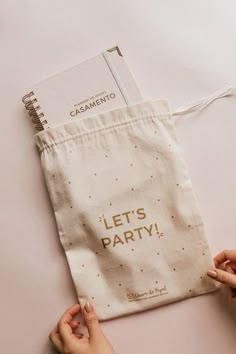 two hands holding a bag with the words let's party written on it