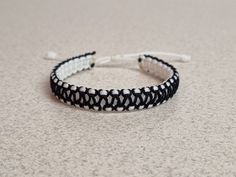 a black and white beaded bracelet sitting on top of a counter