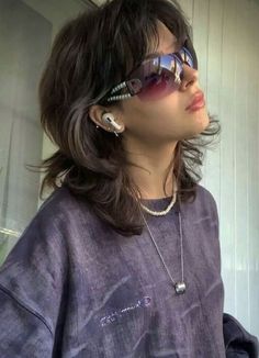 a woman with sunglasses on her head looking off into the distance while wearing a purple shirt