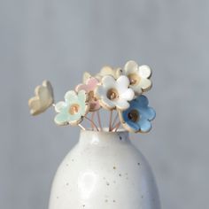 a white vase filled with flowers on top of a table