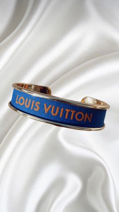 Gold cuff with blue ribbon and orange text. .5" width. 100% authentic luxury ribbon 2.28.23HBETD Louis Vuitton Ribbon, Gold Cuffs, Blue Ribbon, Blue Orange, Victoria Secret, What To Wear, Vogue, Ribbon, Diamonds