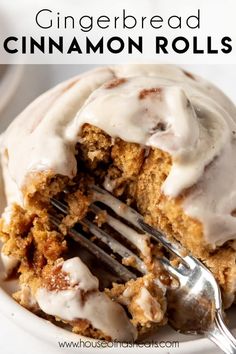 a close up of a plate of food with a fork and cinnamon roll on it