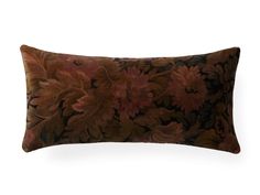 a brown and red floral pillow on a white background