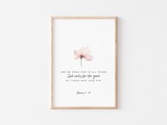 a pink flower with a bible verse on the front in a wooden frame against a white wall