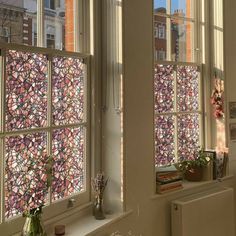 two windows with stained glass in them and some plants on the window sill next to them