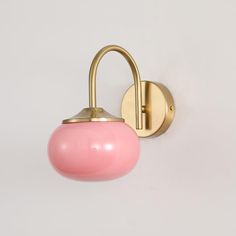 a wall light with a pink glass ball on the front and back of it's arm