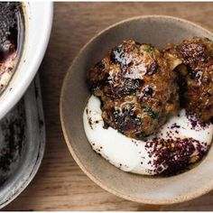 two bowls filled with food sitting on top of a wooden table next to each other