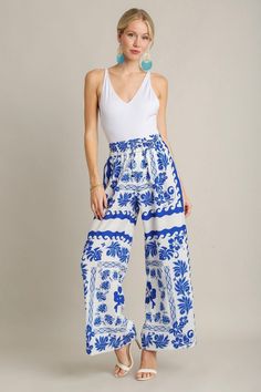 Royal blue and ivory floral print textured wide leg pants Get inspired this season with these stunning ivory and royal blue floral print pants! Featuring a textured fabric with wide legs and an elastic waistband with drawstring. Feel trendy and fashionable at all of your upcoming events! Perfect dressed up with heels and a bodysuit, or worn casually with sandals and a tank top. Shop the look: white eyelet top True to size fit; wide relaxed leg Model is 5'9" wearing a small Fabric doesn't contain