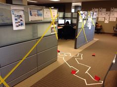 an office cubicle with yellow tape on the floor and desks in the background