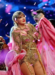 lady in pink and gold outfit on stage with confetti