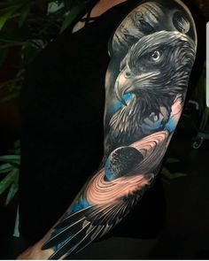 a man with a tattoo on his arm that has an eagle and planets in it