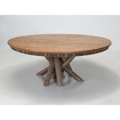 a round wooden table with four branches on the top and one leg in the middle