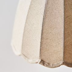 four different shades of fabric hanging from a ceiling lamp shade, one in beige and the other in white