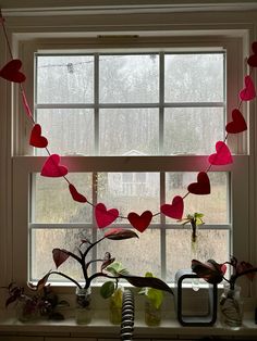 a window sill with hearts hanging from it