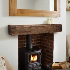 a wood burning stove sitting inside of a living room next to a wall mounted mirror