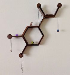 a clock made out of wooden hexagonals and pendulums hanging on the wall