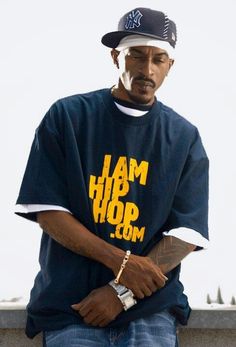 a man wearing a t - shirt that says i am hip com sitting on a ledge