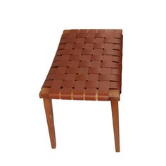 a wooden bench made out of brown leather and some wood strips on the backrest