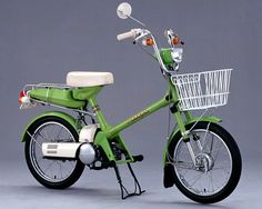 a green scooter with a white basket on the front and back tire rims