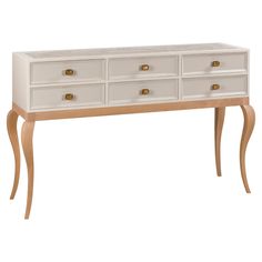 a white dresser with gold handles and drawers on it's legs, against a white background