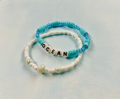 Set of two ocean inspired bracelets, made with stretchy string, friendship bracelet style Adjustable Ocean-inspired Beaded Bracelets, Ocean-inspired Beaded Bracelets With Round Beads, Ocean-inspired Beaded Round Bead Bracelets, Ocean-inspired Beaded Round Bracelets, Beaded Strand Bracelets For Friendship, White Ocean-inspired Strand Friendship Bracelets, Handmade Ocean-inspired Round Beaded Bracelet, Adjustable Ocean-inspired Friendship Bracelets, Ocean-inspired Bracelets With Colorful Beads For Gifts