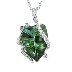 This exquisite color pendant in 18k gold with diamonds showcases a distinctive green tourmaline surrounded by a sparkling band of radiant diamonds. The sophisticated white gold chain elevates the piece, bringing a timeless appeal.¬¨¬®‚Äö√Ñ‚Ä† White Gold Chain, Tourmaline Pendant, White Gold Chains, Radiant Diamond, Green Tourmaline, Designer Engagement Rings, Gold Chain, Tourmaline, Timeless Fashion