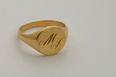 "A classic hand engraved signet ring for men or women, custom engraved solid gold ring in 14k gold. A beautiful 14K yellow gold signet ring. This ring can be customized: It can be hand engraved to up to 3 letters. The engraving can be made with a font of your choosing - you can even write it in your own handwriting - nothing is more personalized than this <3 This minimalist ring is light and comfortable to wear and will be great for everyday use, as for a special occasion. A great and unique Signate Rings, Signet Rings Women Vintage, Ring Initials, Modern Ring Design, Signet Ring Women, Signet Ring For Men, Engraved Signet Ring, Silver Gold Ring, Pinky Signet Ring