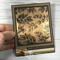 someone holding up a card with leaves on it