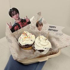 two cupcakes in a paper wrapper with photos on them and one has a birthday card