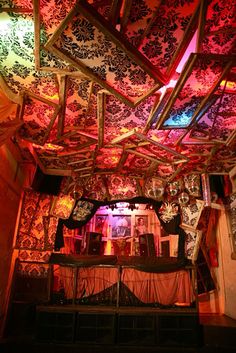 the ceiling is covered with colorful lights and fabric covering it's entire structure,