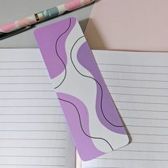 a notepad with a design on it next to a pencil