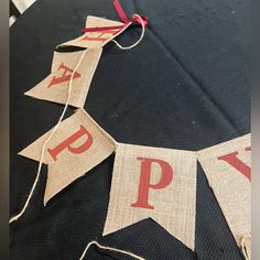 a black table topped with red and white happy buntings on top of it