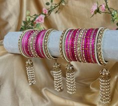 Stunning and unique set of hot pink bangles with pearl kaleereh detailing, comes as a pair for both arms.  With antique gold bangles and champagne zircon crystals. Hot pink metal bangles and beautiful long Kaleereh jhumka bangles! Perfect for your special day  Very limited stock!  Ready to ship 📦 Cheap Pink Traditional Bangle, Pink Kundan Bangle For Festivals, Pink Kundan Bangle For Festive Occasions, Pink Kundan Bangle For Gift, Festive Pink Bangle With Stone Work, Pink Bollywood Bracelets For Celebration, Pink Bollywood Celebration Bracelets, Pink Stone Work Bangle For Wedding, Pink Bangle For Diwali Party