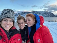 three women are posing for a photo in the snow