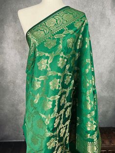 Beautiful GreenColor Floral dupatta with black color tassels. Dupatta has floral Jaal all over. Item: Dupatta Base color : Green with muted Gold Zari Fabric : Soft Silk (Not Pure Silk) Work : Zari Weaved with tassels Length of the Dupatta : 92 inches approx. Width of the dupatta : 35 1/2 inches (Approx.) Store Policies - No return or exchange will be accepted for color variations. - No return or exchange will be accepted if the color does not match your other clothing or your partners or anyone else. - Since this Dupatta is handmade hence little inconsistencies may be there however it is not considered as a defect. - Zari or thread coming out or on folds is not considered as defects. - Slight variation in actual color vs. image is possible due to the screen resolution. - For more Store pol Festive Green Shawl With Traditional Patterns, Green Shawl With Pallu In Traditional Drape, Green Jamawar Dupatta Shawl, Traditional Green Pashmina Dupatta Shawl, Green Shawl With Traditional Patterns For Festivals, Green Pashmina Shawl Dupatta For Wedding, Traditional Green Pashmina Shawl Dupatta, Green Zari Weaving Dupatta For Celebration, Green Katan Silk Dupatta For Celebration