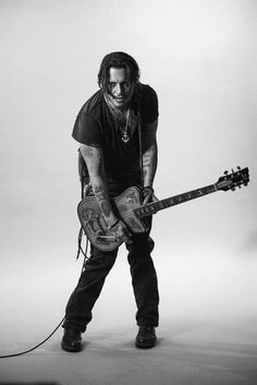 a black and white photo of a man holding a guitar