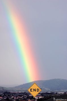 a rainbow appears in the sky over a rural area