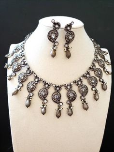 High quality Indian oxidized silver collar bib neckalce with sparkly CZ stones, pearls. Perfect for any party or evening gathering. Wear your hair up or down. The metal is a soft grey color, shined to a soft lustre, to better show off the sparkly stones. Overall effect is stunning! An elegant design that is flattering on everyone! Suspended from a detailed floral chain. Matching earrings. Excellent finish and craftsmanship. Shop necklaces: https://www.etsy.com/shop/BoutiqueByMaryam?section_id=21 Heavy Silver Kundan Necklace For Festive Occasions, Festive Silver Chandbali Kundan Necklace, Silver Chandbali Kundan Necklace, Bollywood Oxidized Finish Necklaces For Festivals, Handmade Silver Kundan Necklace, Silver Kundan Necklace With Intricate Design, Bollywood Style Oxidized Necklaces For Festivals, Festive Silver Kundan Necklace With Oxidized Finish, Bollywood Oxidized Necklace For Festivals