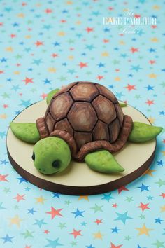 a cake shaped like a turtle sitting on top of a plate with stars around it