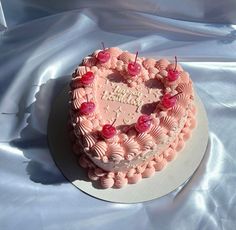 a heart shaped birthday cake with cherries on it