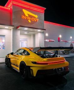 a yellow sports car parked in front of a fast food restaurant