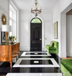 the front cover of an interior design book, featuring green chairs and black door with white trim