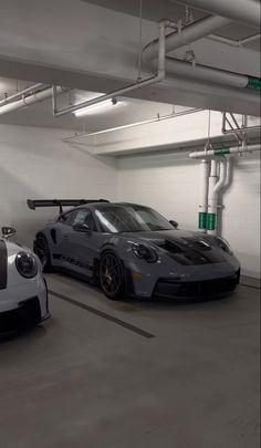 two cars parked in a parking garage next to each other